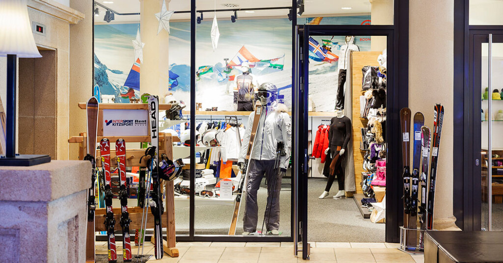 Ski shop with skis, winter clothing, and a mountain mural inside.