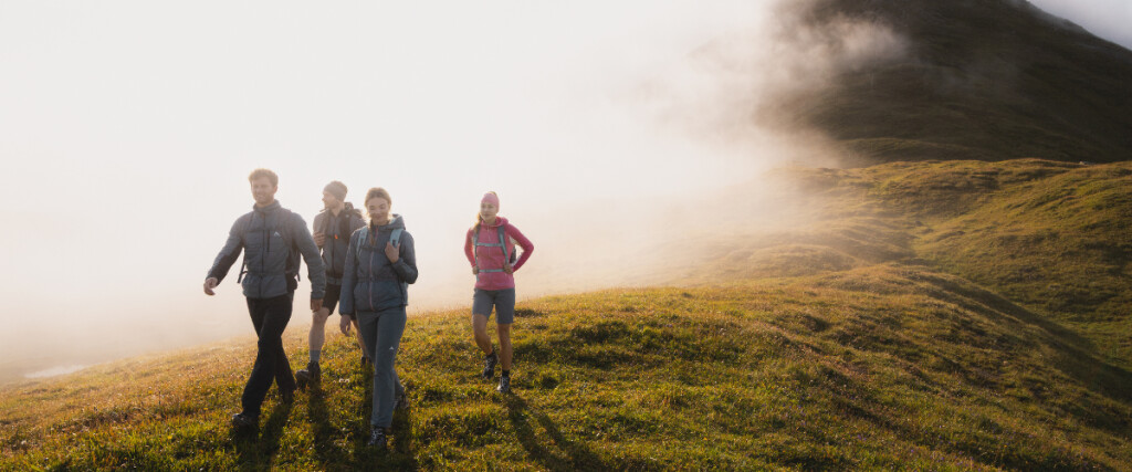 Paar wandert mit Trekkingstöcken auf einem Bergpfad. Outdoor-Abenteuerreise.