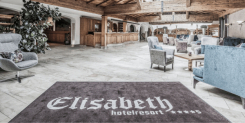 Hotel Elisabeth Resort Lobby mit Rezeption, Sitzecke und Fußmatte.