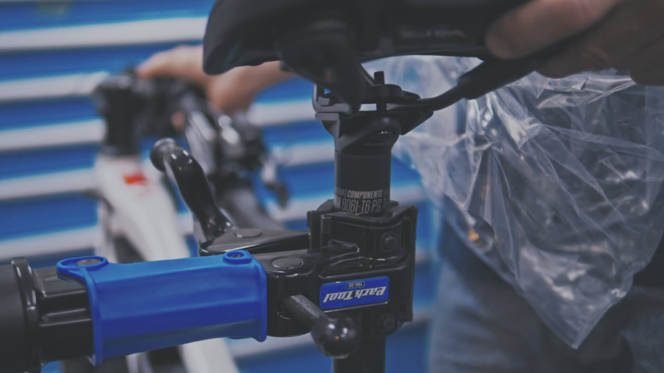 Nahaufnahme eines Fahrradreparaturständers, bei dem der Fahrradsattel für Wartungsarbeiten oder eine individuelle Anpassung eingestellt wird.