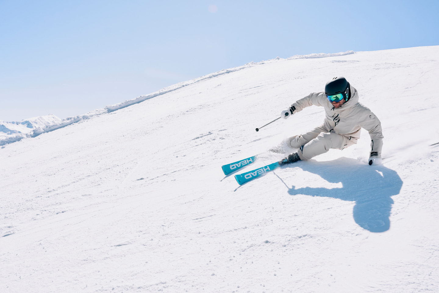 Zwei Skifahrer fahren an einem sonnigen Tag in einem Bergskigebiet Ski bergab.